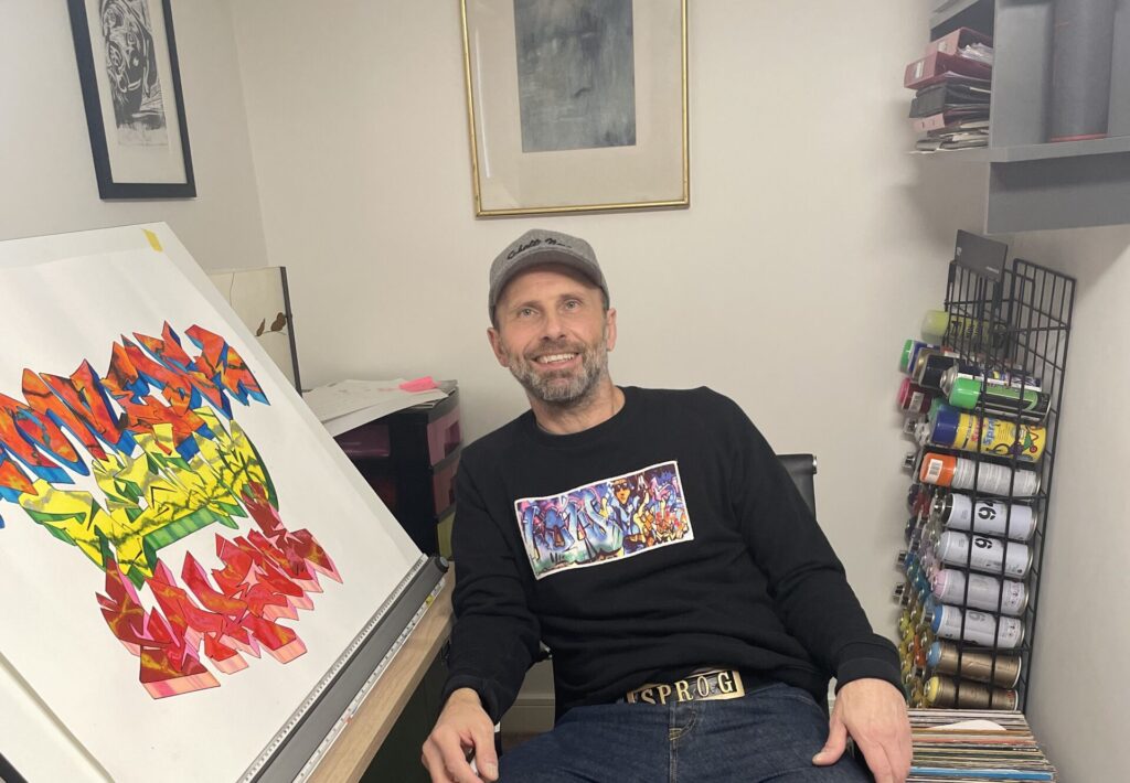 Showing off completed graffiti art in the studio